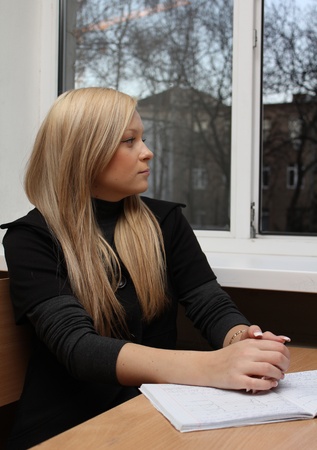 pensive girl near the windowの写真素材