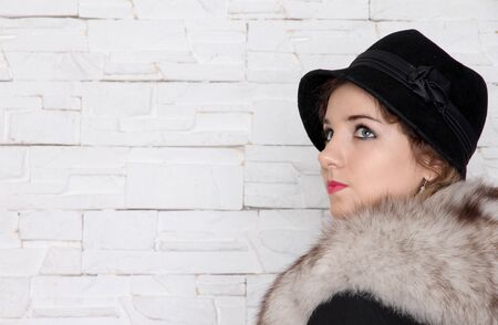 The young retro woman in the black hat