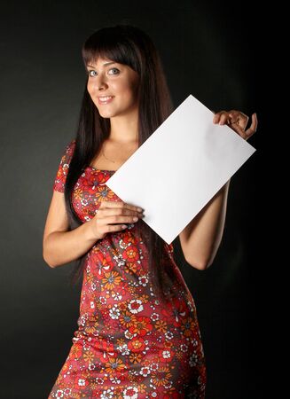 Young attractive woman with white sheet of paperの写真素材