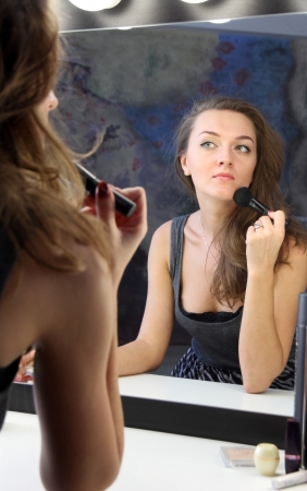 The nice woman with make up brush near mirrorの写真素材