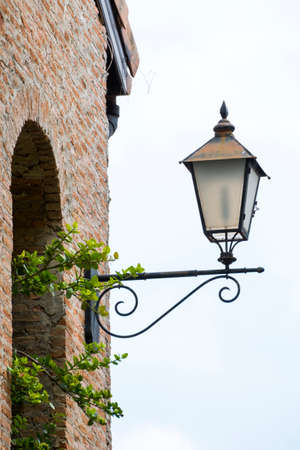 An old lamp with a beautiful orange brick wall of the building.の写真素材