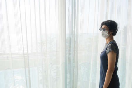 Asian female tourists wear gray clothes, glasses and face masks in State Quarantia.の写真素材