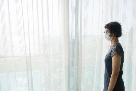Asian female tourists wear gray clothes, glasses and face masks in State Quarantia.の写真素材