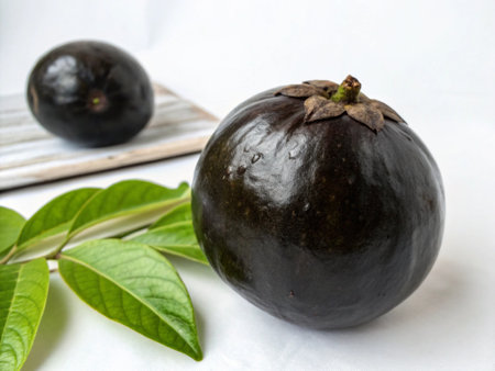 Black mangosteen with leaves on a white background, Thailand.の写真素材