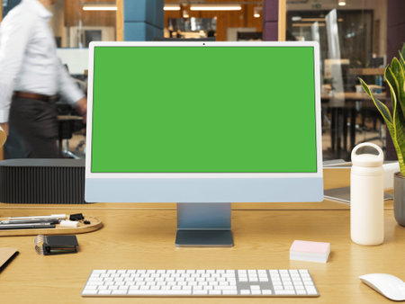 Computer with blank green screen on wooden desk in office. Mock upの写真素材