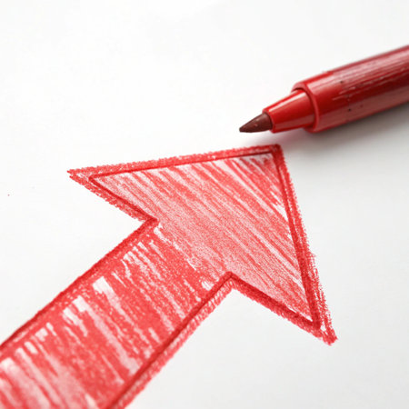 Red pencil drawing a red arrow on white paper. Conceptual image.の写真素材