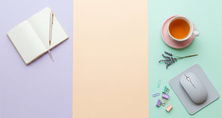 Flat lay of workspace with computer mouse, notebook and cup of tea on colorful backgroundの写真素材