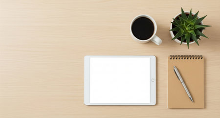 Top view of modern workplace with tablet, coffee cup and notebook on wooden tableの写真素材