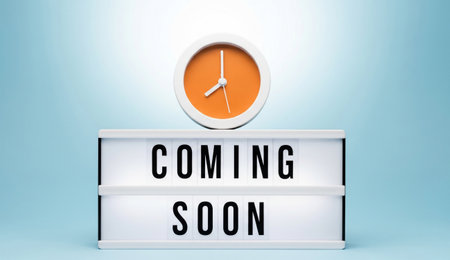 a coming soon message on a light box with a clock on top against a light blue colored background.の写真素材
