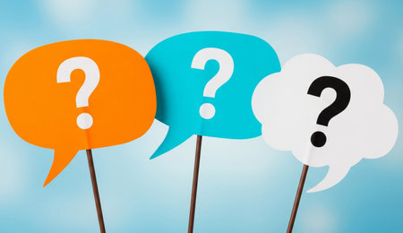 three speech bubbles in orange, blue, and white, each with a question mark, set against a blurred blue background.の写真素材