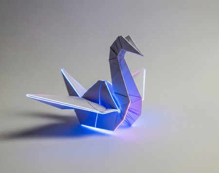 a paper origami crane with blue and pink neon lights on a plain studio backgroundの写真素材