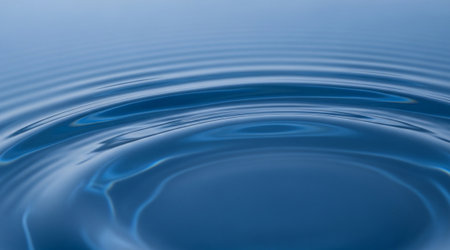 Blue water ripple close up. Concentric circular waves. Abstract liquid reflection surface background.の写真素材