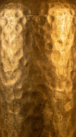 Deeply textured hammered gold, with visible cracks and warm illumination, providing a rich, luxurious feel.の写真素材