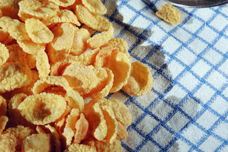A bunch of corn flakes cereal on a white background with milk. Breakfastの写真素材