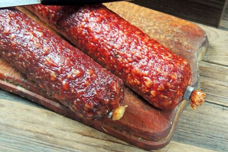 Sausage and spices on vintage wooden boards closeup