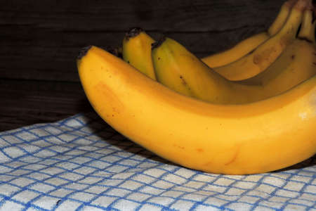 Bananas on a wooden picnic table .の写真素材
