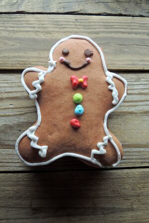 Gingerbread cookies hanging over wooden background .