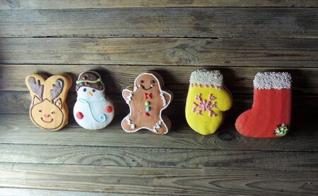 Gingerbread cookies hanging over wooden background .の写真素材