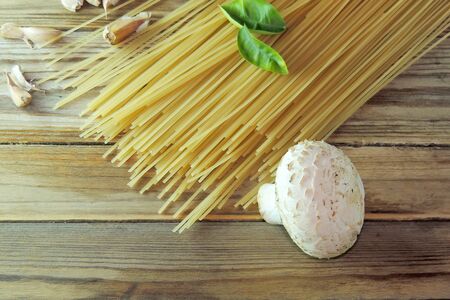 Spaghetti, mushrooms and garlic on wooden backgroundの写真素材