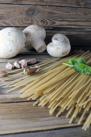 Spaghetti, mushrooms and garlic on wooden backgroundの写真素材