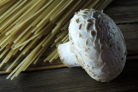 Spaghetti, mushrooms and garlic on wooden backgroundの写真素材