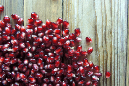 Pomegranate seeds on a wooden background .の写真素材