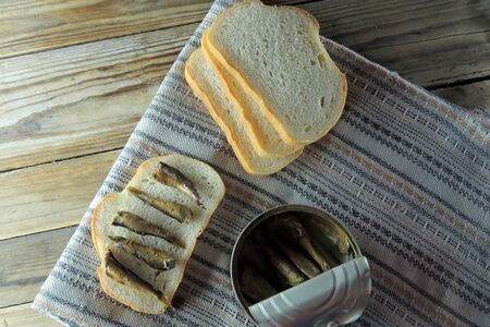 A tin of smoked sprats and bread. On sandwiches