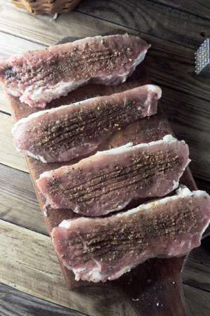 Raw meat selection on wooden cutting board with knifeの写真素材