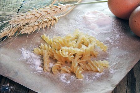 Whole eggs, pasta and several wheat ears