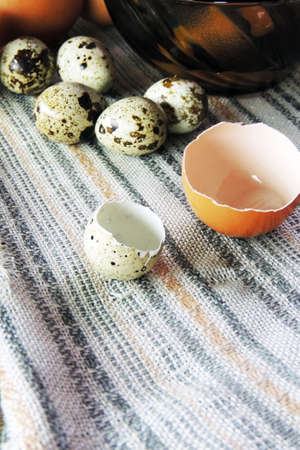 Chicken and quail eggs, wheat on wooden table