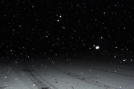 Real falling snow on a black background for use as a texture layer in your project.の写真素材