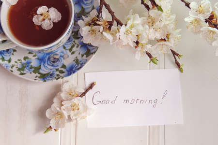 Tea, blossoming apricot twig and the inscription Good morningの写真素材