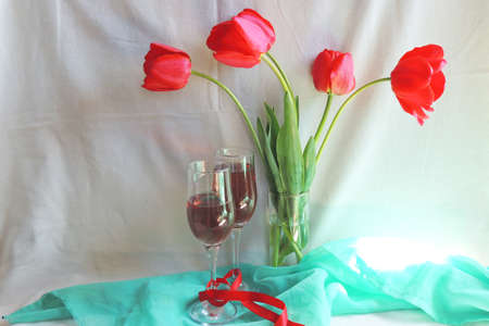 Red tulips and wine in a fallen glass. The rain is falling.の写真素材