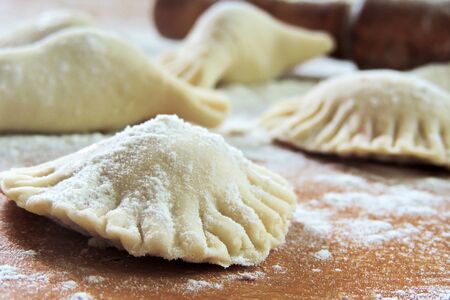 Many dumplings on wooden desk with flour and rocking