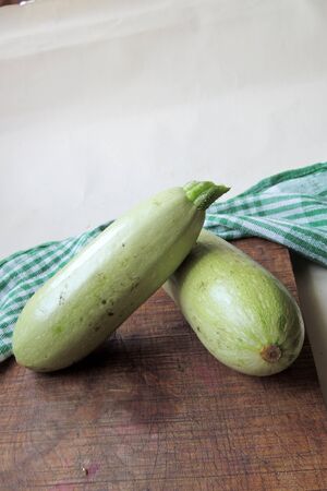 Fresh zucchini on wooden board . .の写真素材