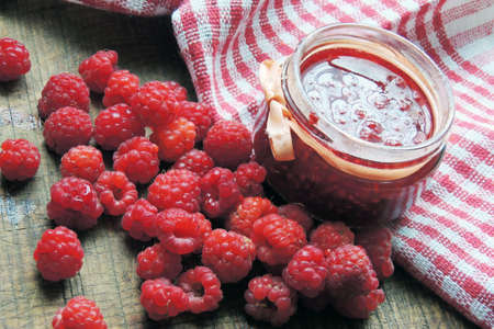 Raspberry jam and fresh raspberry on a rustic wooden table.Selective focus.の写真素材