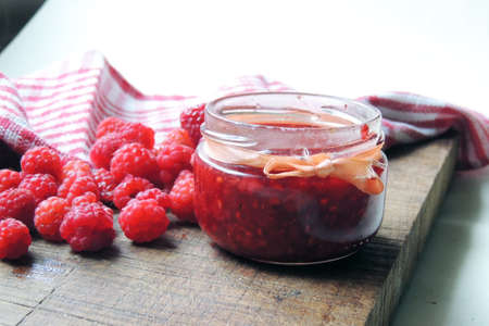 Raspberry jam and fresh raspberry on a rustic wooden table.Selective focus.の写真素材