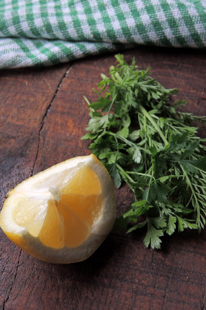 sliced lemon and green herbs on a wooden backgroundの写真素材