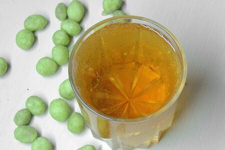Beer and peanuts on the wooden background. Viewed from above.