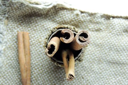 Cinnamon sticks and powder on rustic wooden board, top view