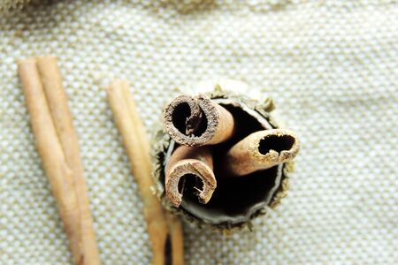 Cinnamon sticks and powder on rustic wooden board, top viewの写真素材