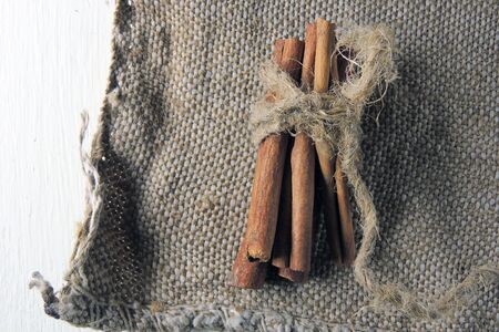 Cinnamon sticks and powder on rustic wooden board, top viewの写真素材