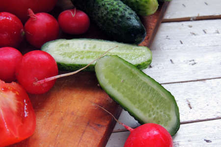 Fresh vegetables: Tomatoes, radishes and cucumber on wooden backgroundの写真素材