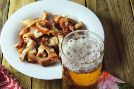 Smoked pig ears are sliced in a dish with beer. Beerの写真素材