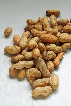 Close up peanut on wood table and linen sack at rural organic farm