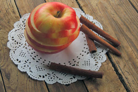 Fresh ripe red apples and cinnamon sticks on wooden background.の写真素材