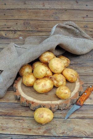 Potato. Fresh Young Potatoes With Sackcloth On Old Gray Wooden Table Top View.の写真素材
