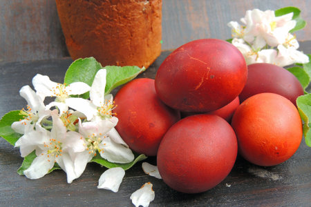 Easter eggs and jasmine flowers on a wooden background.