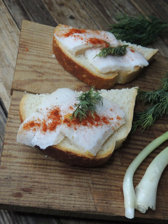 Sandwiches with herring and dill on a wooden boardの写真素材