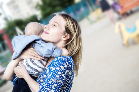 Prettyl happy mather with baby boy Embracing him emotionally on a likingの写真素材